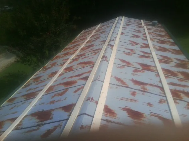 Rusted metal roof panels with new wood purlins before replacement — Storm Damage Roof Repair in Laurelville by Roofing Brothers