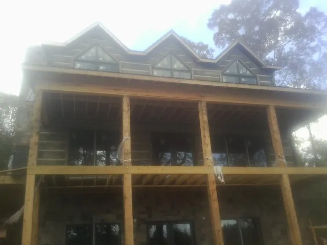 Dormers and porch framing on a large log home under construction — Roof Coating work by our crew in Laurelville