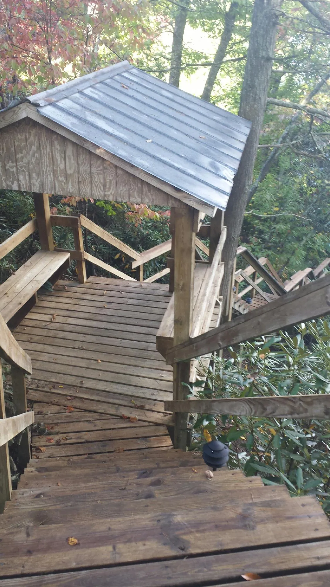 Metal roofed shelter over wooden steps on a wooded walkway — Skylight Repair & Installation work by our crew in Laurelville