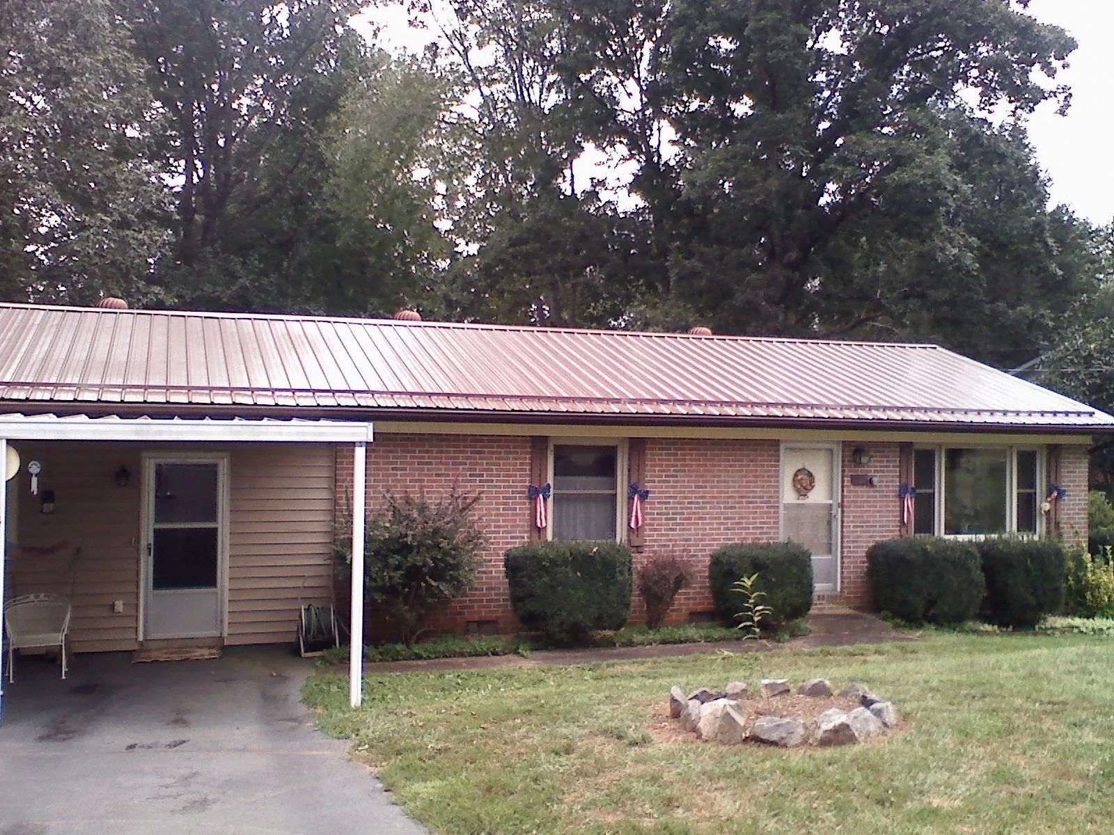 Bronze metal roof and carport on a brick ranch home — Roof Repair work by our crew in Laurelville